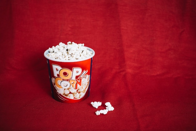 Kostenloses Foto popcorn eimer auf rotem stoff