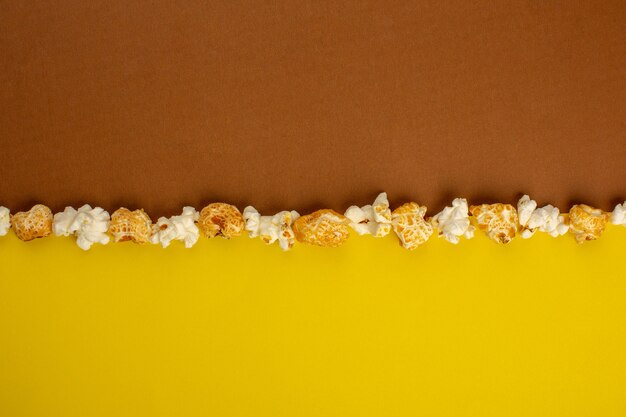 Popcorn frisch gesalzen und süß auf einem gelbbraunen Schreibtisch