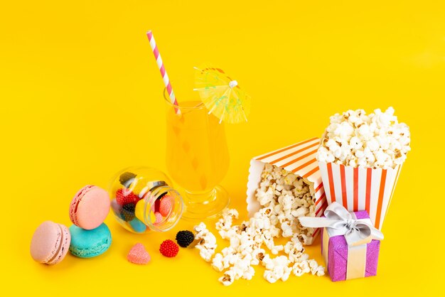 Popcorn und Cocktail von vorne mit französischen Macarons und Confitures auf Gelb
