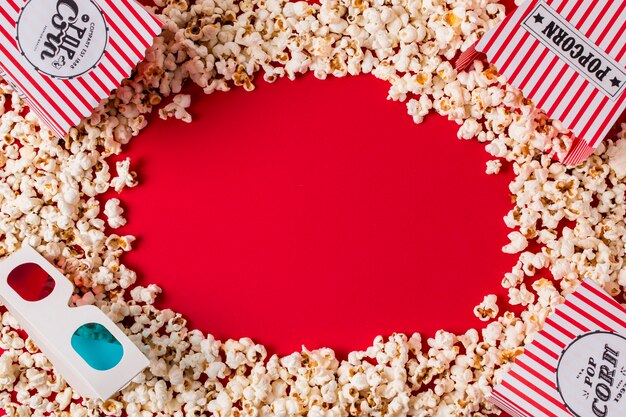 Kostenloses Foto popcorn und gläser 3d mit kopienraum für das schreiben des textes auf roten hintergrund