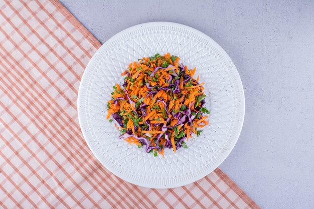 Portion Kohl- und Karottensalat auf Marmorhintergrund. Foto in hoher Qualität