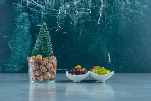 Portionen von Bonbons und Popcorn-Süßigkeiten auf Marmor.