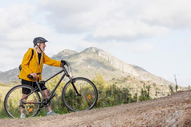 Porträt älterer Mann mit Fahrrad auf Berg