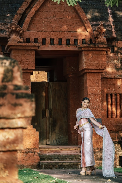 Porträt asiatische charmante Frau mit schöner typischer thailändischer Identitätskultur Thailands in einem alten Tempel oder einem berühmten Ort mit anmutiger Pose