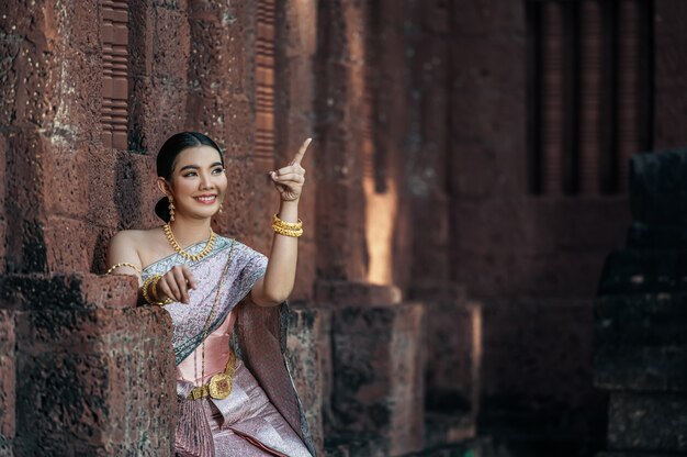 Porträt asiatische charmante Frau mit schöner typischer thailändischer Identitätskultur Thailands in einem alten Tempel oder einem berühmten Ort mit anmutiger Pose