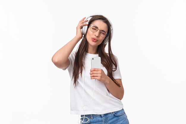 Porträt ausdrucksstarke junge Frau mit mobiler Musik hören
