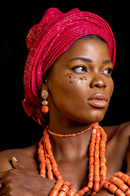 Porträt der afrikanischen Frau, die traditionelle Accessoires trägt und wegschaut
