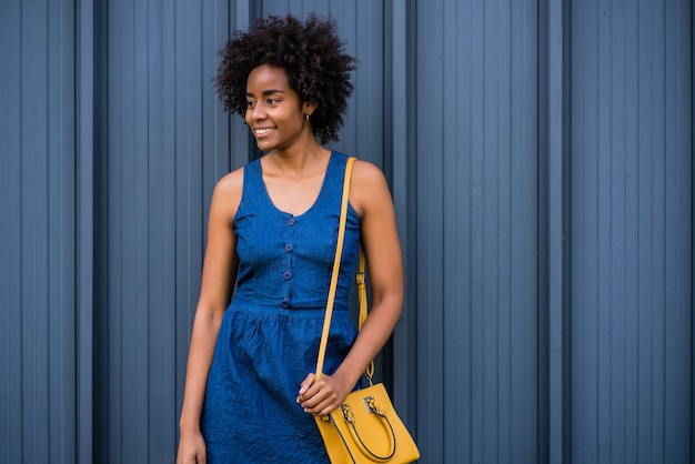 Porträt der Afro-Geschäftsfrau, die lächelt, während sie draußen auf der Straße steht. Geschäfts- und Stadtkonzept.
