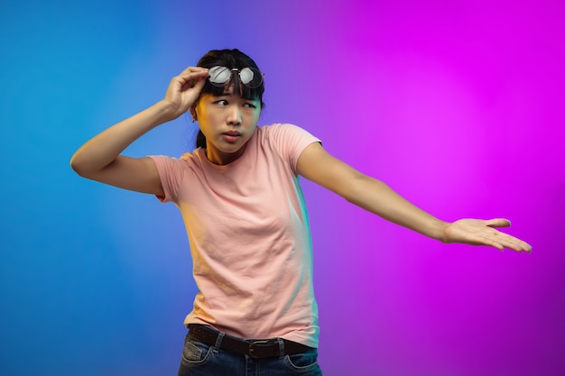Porträt der asiatischen jungen Frau auf Gradientenstudiohintergrund in Neon. Schönes weibliches Modell im lässigen Stil.