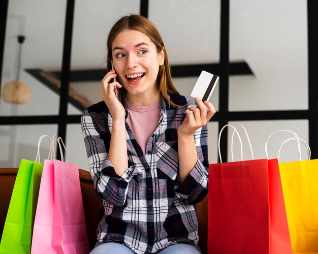 Porträt der aufgeregten Frau sprechend am Telefon