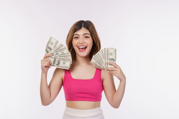 Porträt der aufgeregten jungen Frau, die Bündel Dollarbanknoten lokalisiert über weißem Hintergrund hält