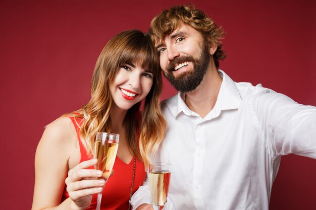 Porträt der brünetten Frau mit ihrem Mann, der ein Glas Champagner hält