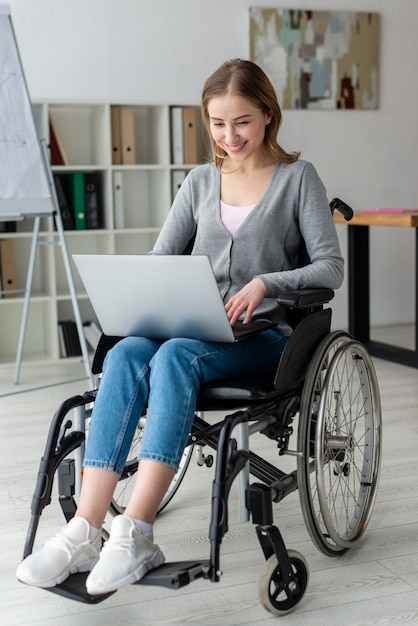 Porträt der erwachsenen Frau, die an einem Laptop arbeitet