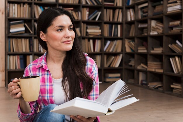 Porträt der erwachsenen Frau, die ein Buch hält