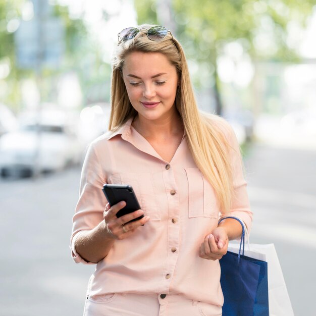 Porträt der erwachsenen Frau, die Handy durchsucht