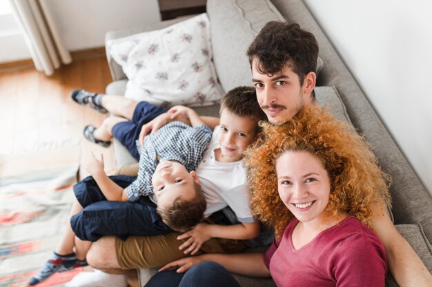 Porträt der Familie zu Hause sitzend auf Sofa