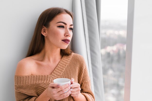 Porträt der Frau, die einen Kaffee hält