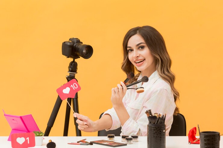 Kostenlose Foto porträt der frau, die glücklich ist, make-up-video aufzunehmen