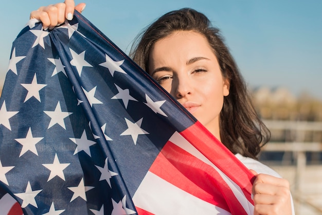 Porträt der Frau, die große USA-Flagge hält