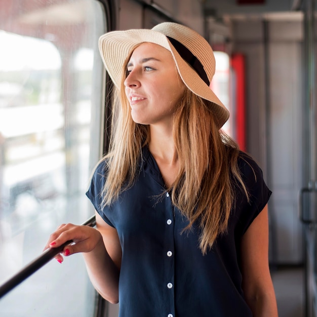 Porträt der Frau, die Hut im Zug trägt
