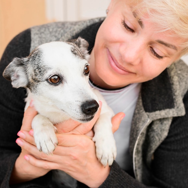 Porträt der frau, die ihren hund hält