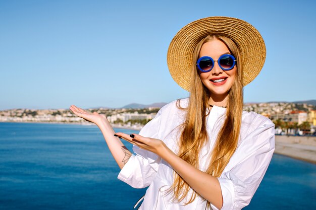 Porträt der Frau, die nahe blaues Meer an der französischen Stadt Cannes aufwirft