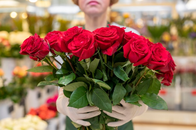 Kostenloses Foto porträt der frau, die sammlung der roten rosen hält