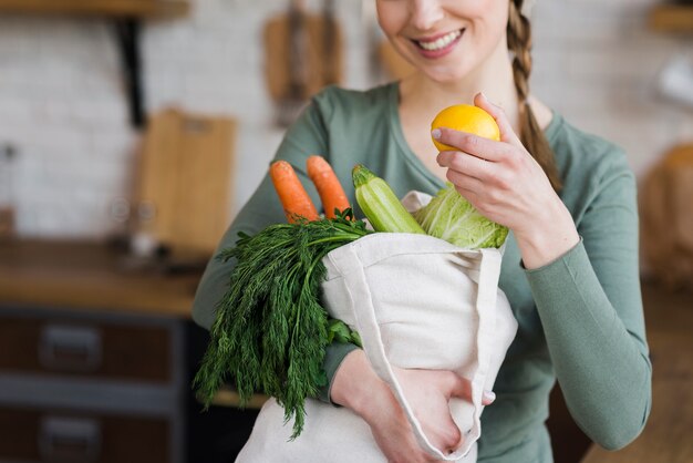 Porträt der Frau, die Tasche mit frischem Gemüse hält
