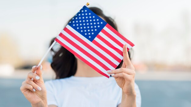 Porträt der Frau, die USA-Flagge über Gesicht hält