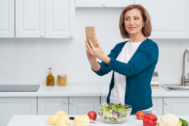 Porträt der Frau ein selfie in der Küche nehmend