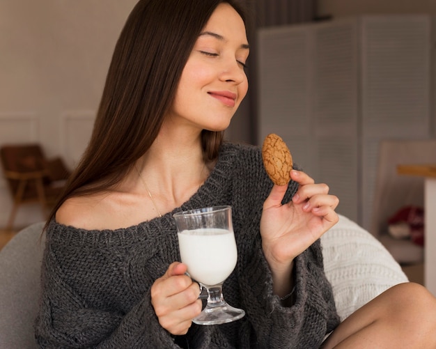 Porträt der Frau im Sessel mit Keks und Milch