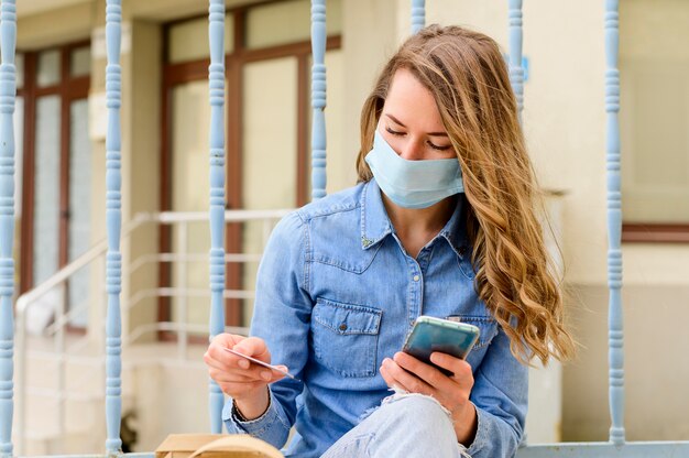 Porträt der Frau mit Gesichtsmaske, die Taschen prüft