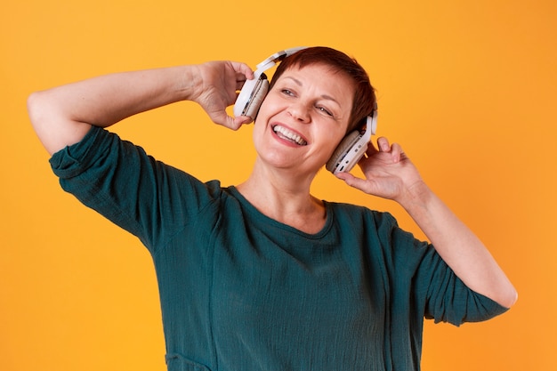 Porträt der glücklichen älteren Frau, die Musik hört