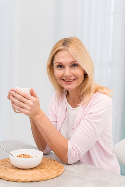 Kostenloses Foto porträt der glücklichen erwachsenen frau, die eine schale hält