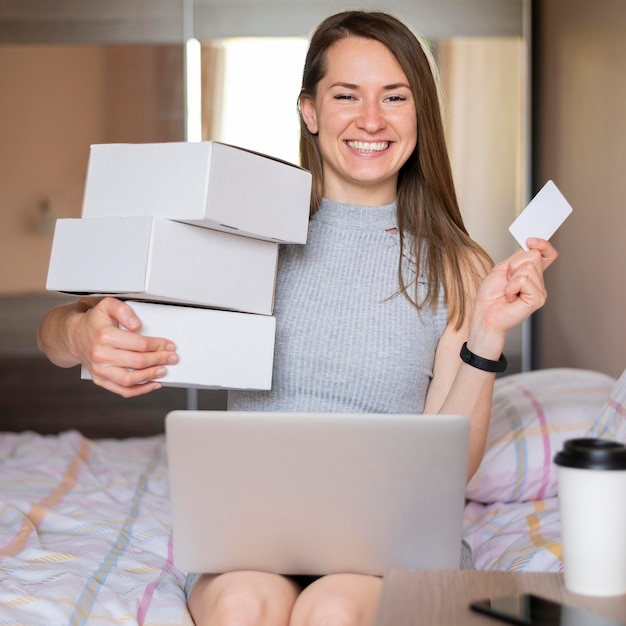 Porträt der glücklichen Frau, die Einkaufsboxen hält