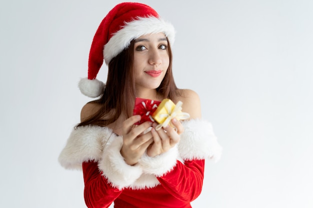 Porträt der glücklichen Frau in Santa Claus-Kleid, das Geschenkboxen hält