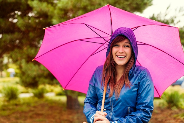 Porträt der glücklichen Frau mit Regenschirm