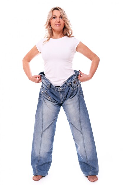 Porträt der glücklichen gealterten Frau, die große Jeans trägt
