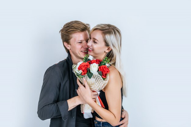 Porträt der glücklichen jungen Paarliebe zusammen mit Blume