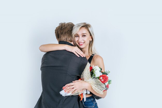 Porträt der glücklichen jungen Paarliebe zusammen mit Blume