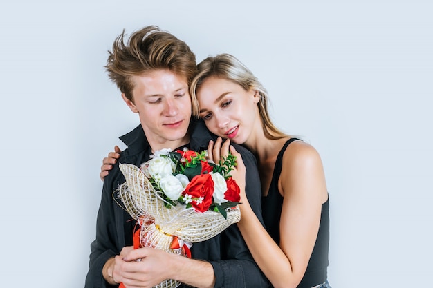 Porträt der glücklichen jungen Paarliebe zusammen mit Blume