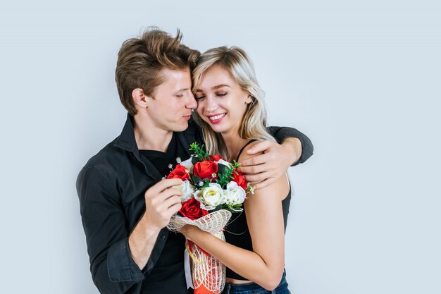 Porträt der glücklichen jungen Paarliebe zusammen mit Blume