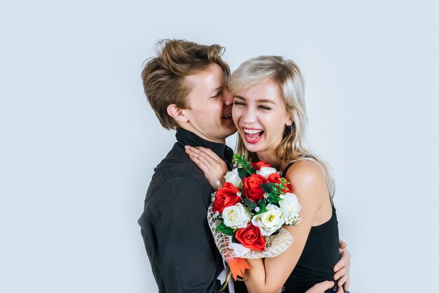 Porträt der glücklichen jungen Paarliebe zusammen mit Blume
