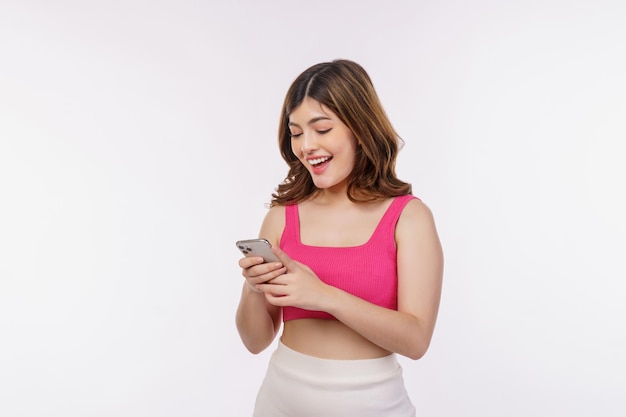 Porträt der glücklichen lächelnden jungen Frau, die den Handy lokalisiert über weißem Hintergrund verwendet