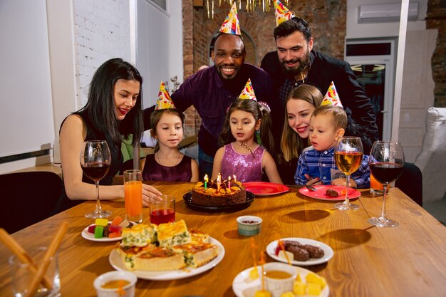 Porträt der glücklichen multiethnischen Familie, die einen Geburtstag zu Hause feiert