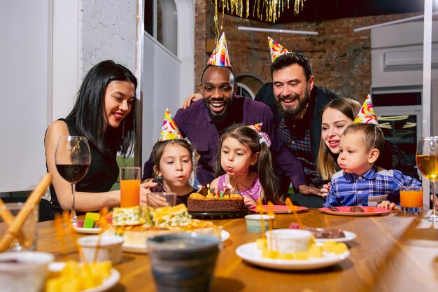 Porträt der glücklichen multiethnischen Familie, die einen Geburtstag zu Hause feiert