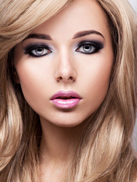 Porträt der hübschen attraktiven jungen Frau mit hellem Make-up. Schön braunhaarig.
