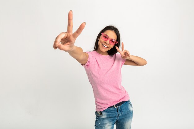 Porträt der hübschen lächelnden emotionalen Frau im rosa Hemd und in der Sonnenbrille, die ihre Arme vorwärts halten
