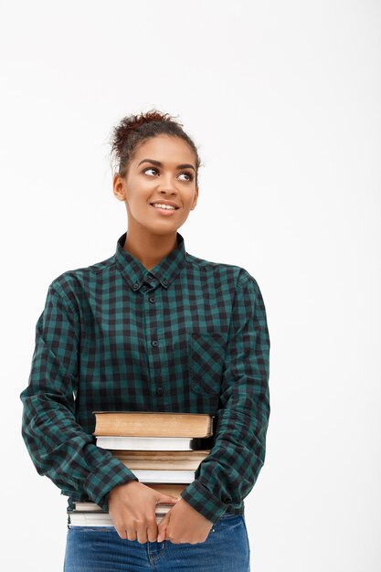 Porträt der jungen afrikanischen Frau mit Büchern auf Weiß.