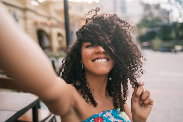 Porträt der jungen afroamerikanischen Frau, die ein Selfie draußen in der Straße nimmt. Das Leben genießen. Lifestyle-Konzept.
